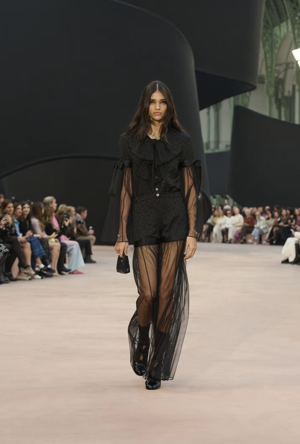 	Model carrying Chanel micro 31 bag in black metallic tweed – Fall Winter 2025/26