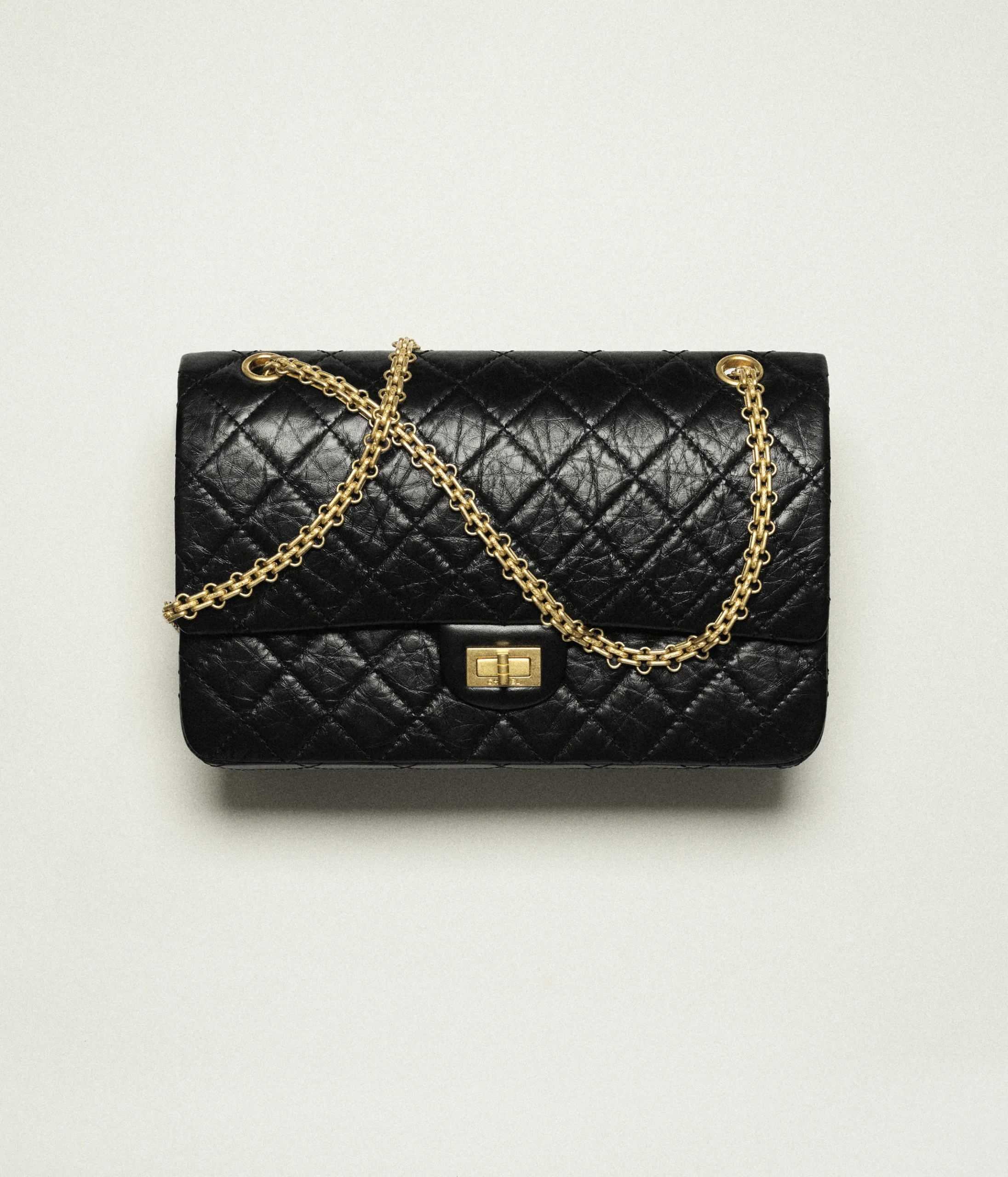 Black quilted Reissue on marble background Chanel 2.55 bag history