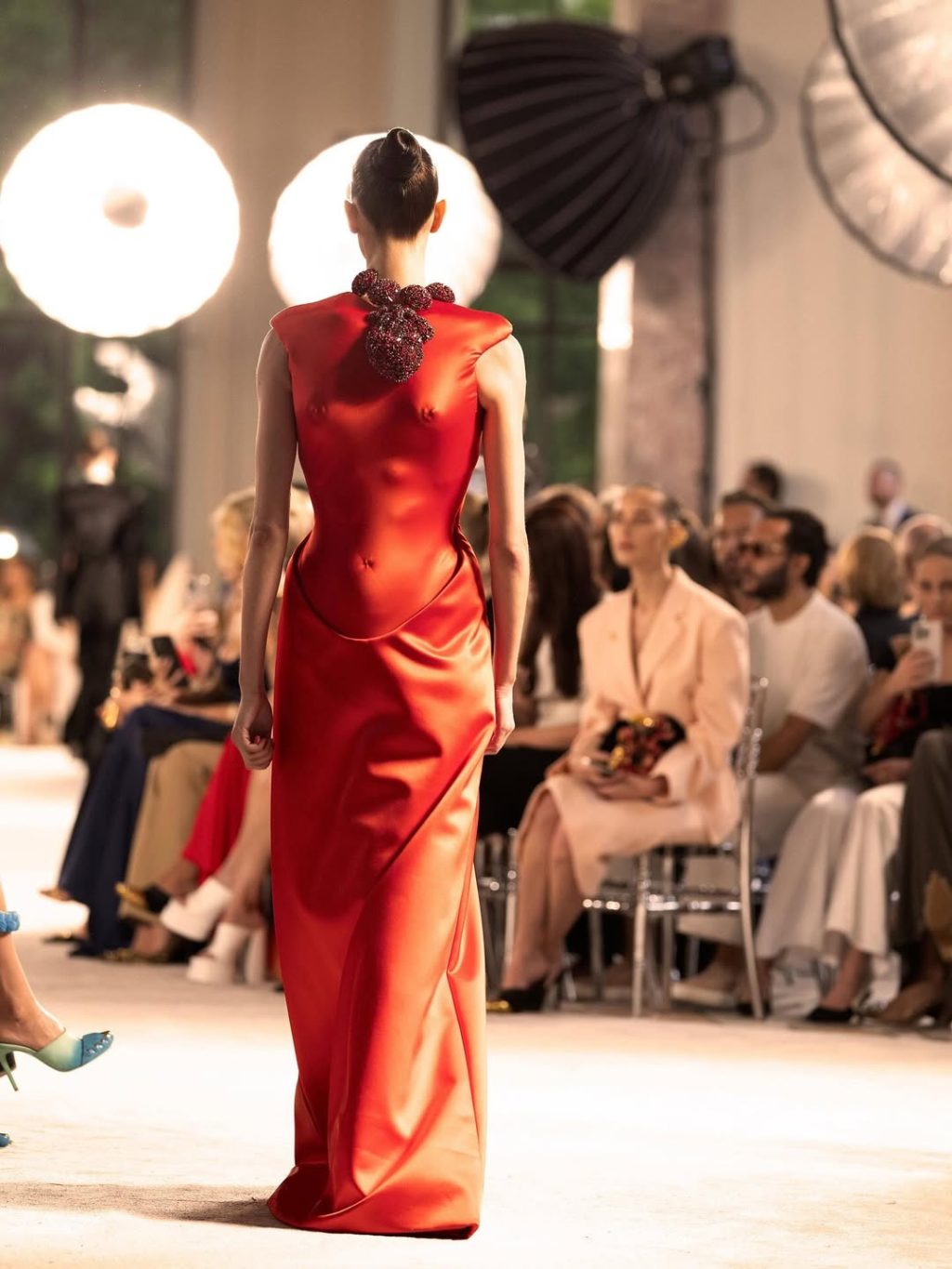 Reversed torso at “Back to the future” Schiaparelli by Daniel Roseberry f/w haute couture 2025, reminiscing of the “Death Becomes Her” (1992) film. The look is adorned by a red satin heeled pumps with a strap held with a silver metal hand-shaped jewel, which is a replica of the “Royal Heart” by Salvador Dali crafted in 1953